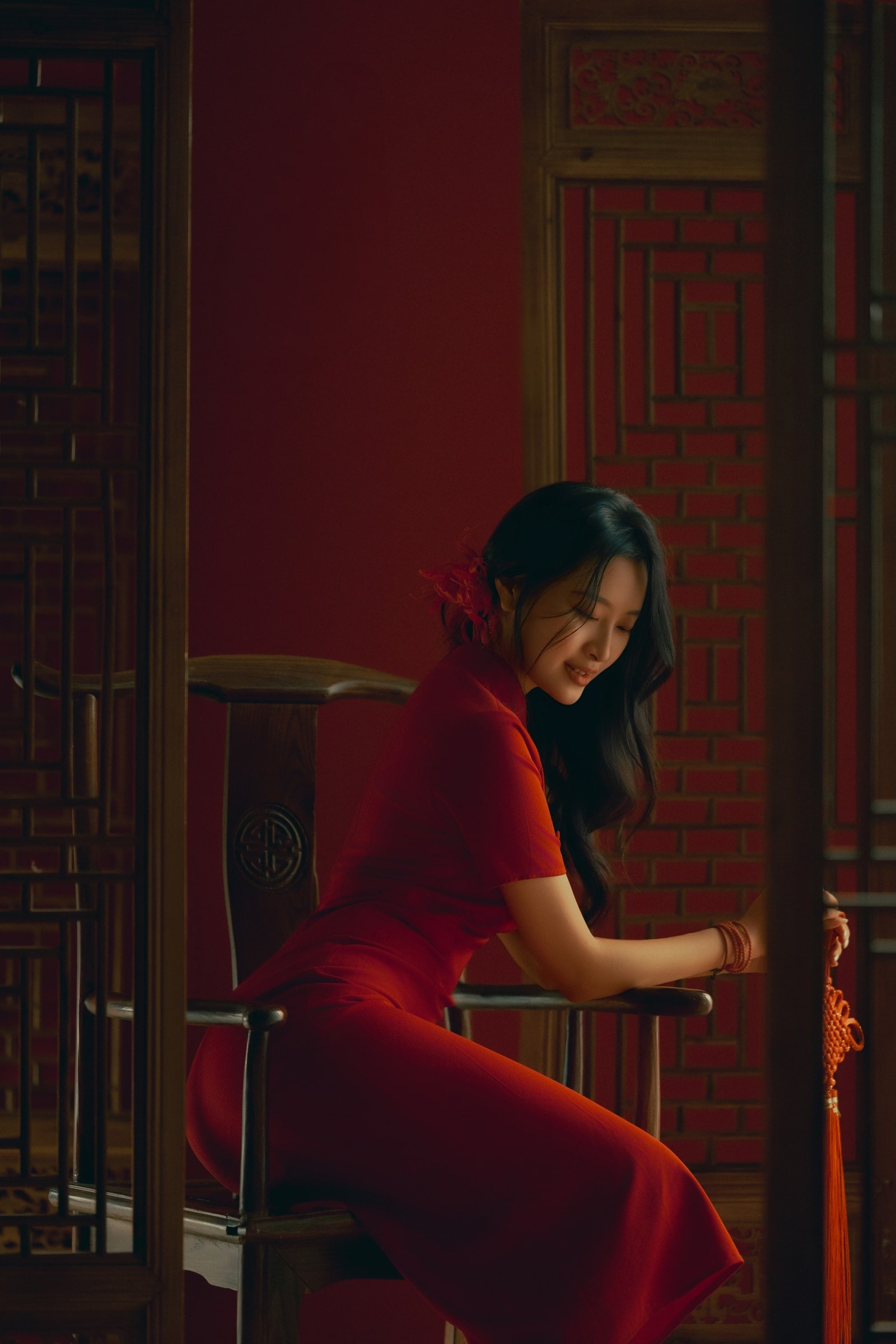Solo portrait in red qipao against carved wooden screen
